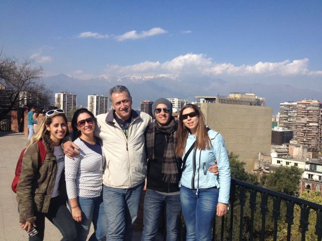 Estamos todos em pé no Cerro Santa Lucia, ao bem ao fundo aparece a Cordilheira dos Andes com neve