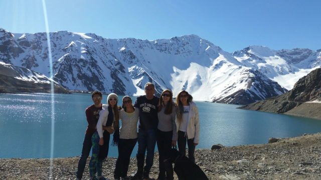 Foto de toda família no Embalse, estamos em pé, ao fundo aparece o lago e Cordilheira dos Andes